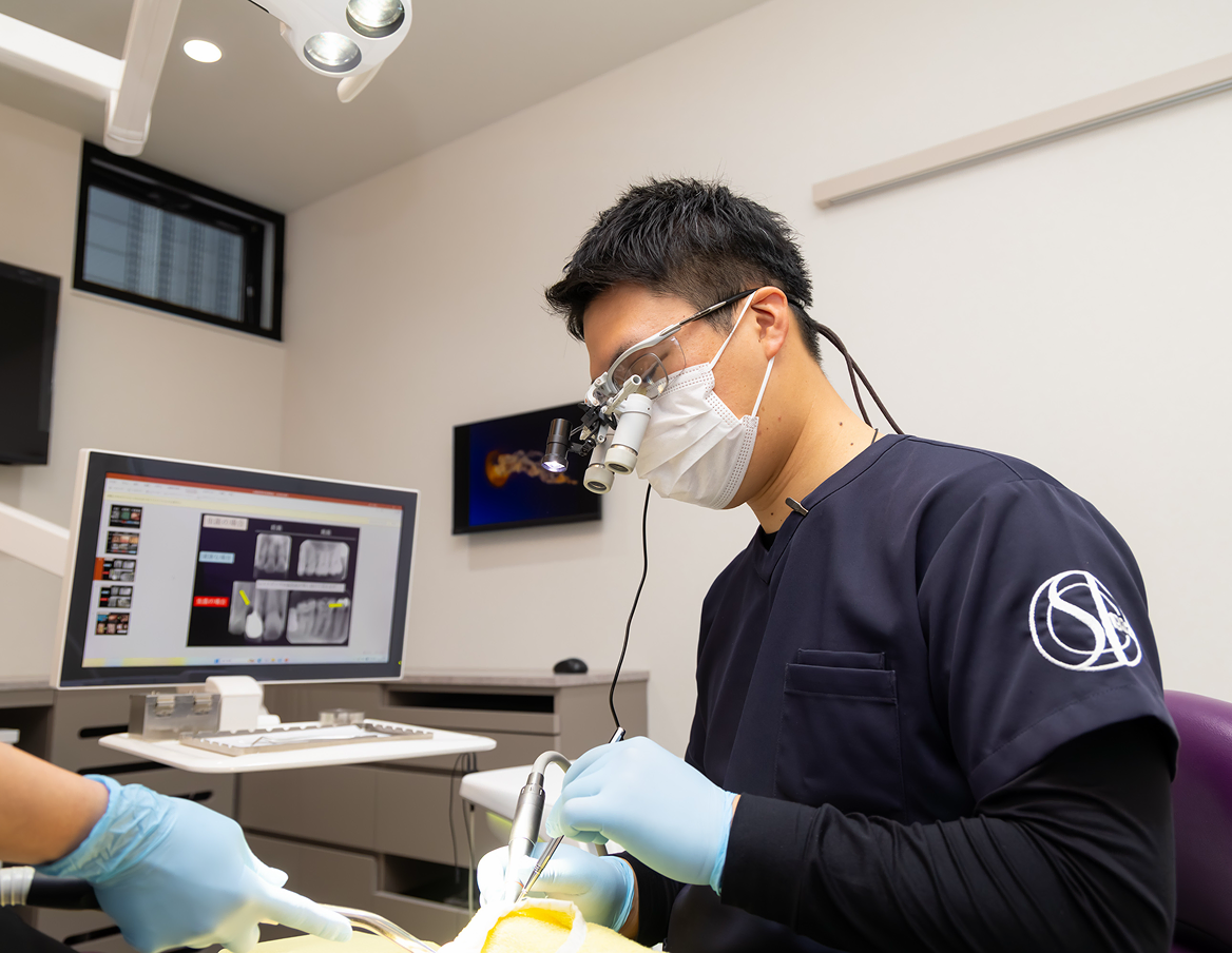 拡大鏡を装着して治療にあたる歯科医師