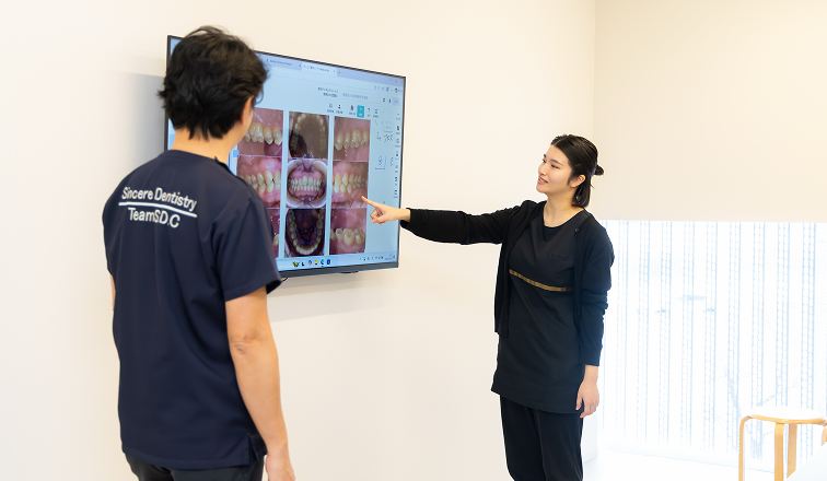 認定歯科衛生士がモニターを使って説明する様子