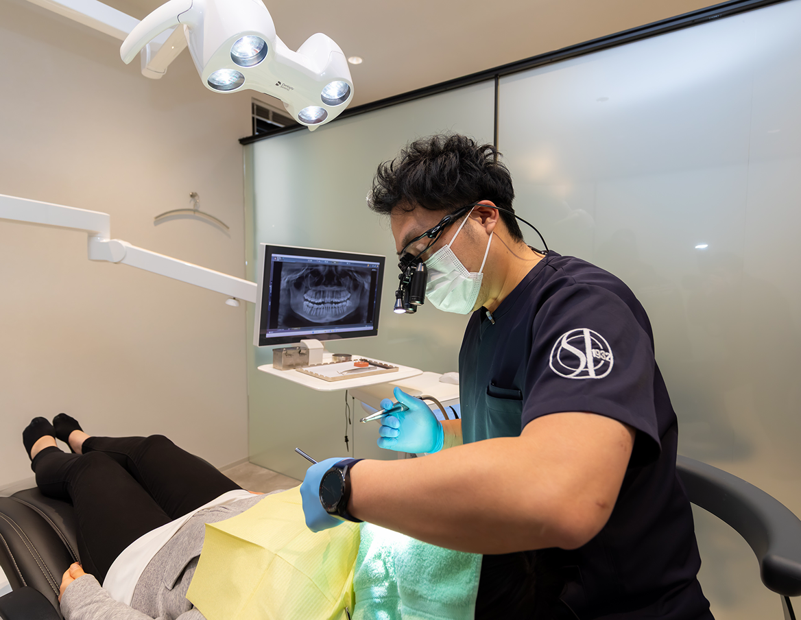 根管治療で精密処置を行う歯科医師