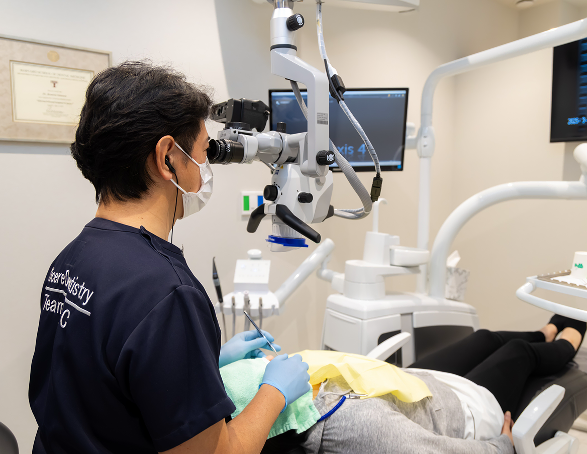 歯周病治療で拡大鏡を用いて診療する様子