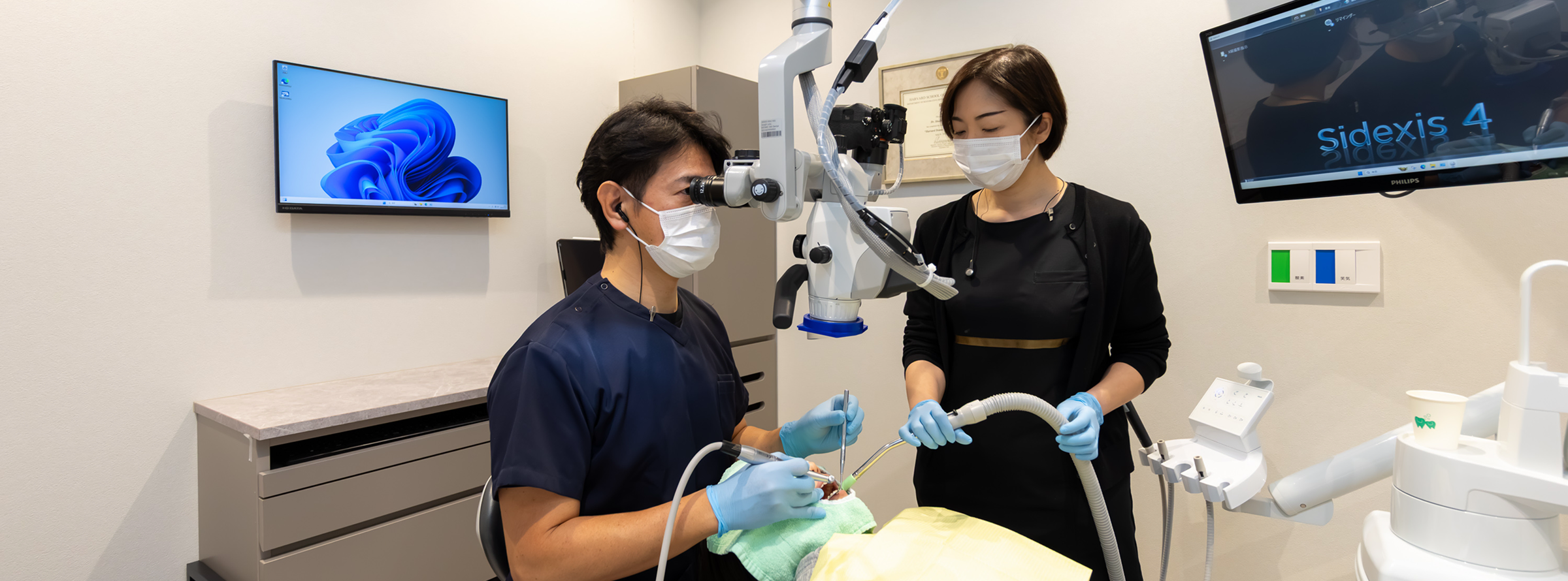 日本歯周病学会専門医がマイクロスコープを用いて診療する様子