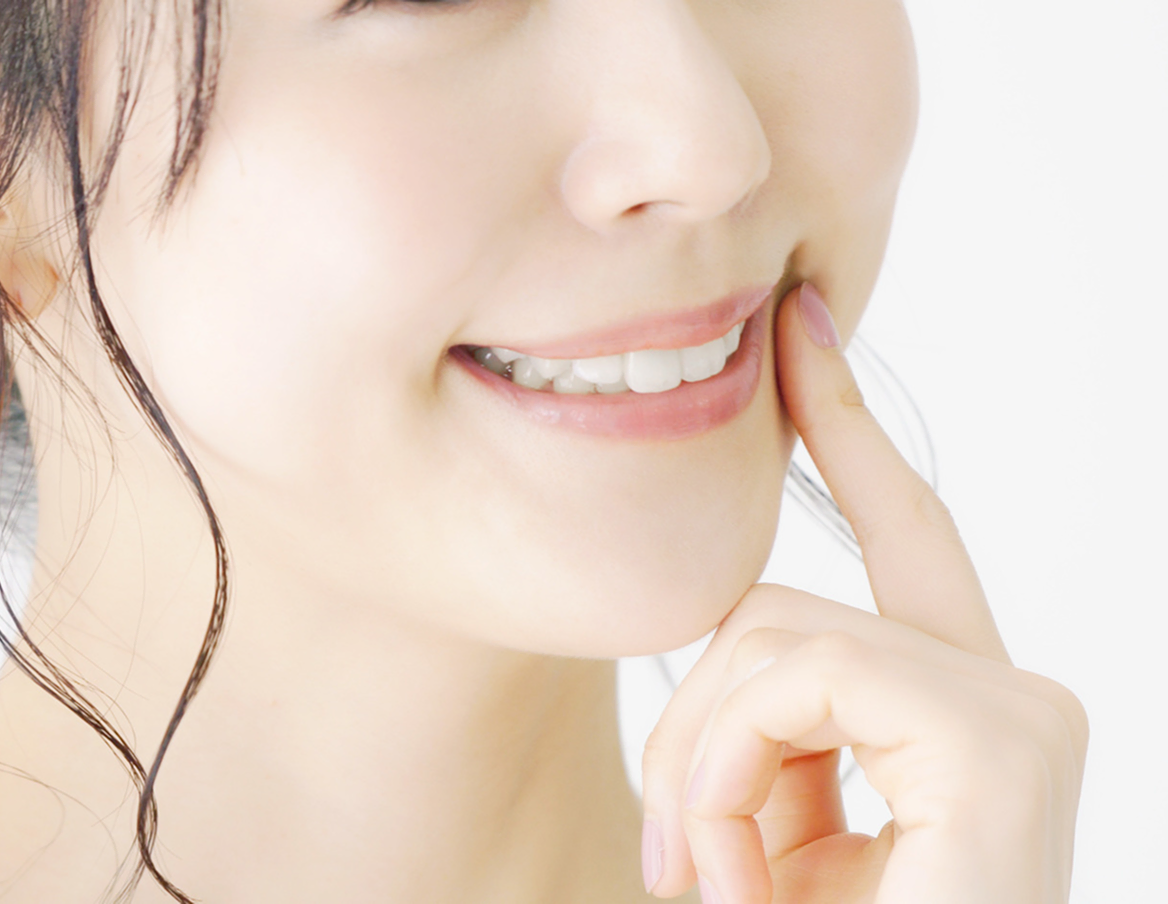 口元に手を添えた女性の笑顔